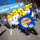 A group of people dressed as legos cross the finish line of a 10K race